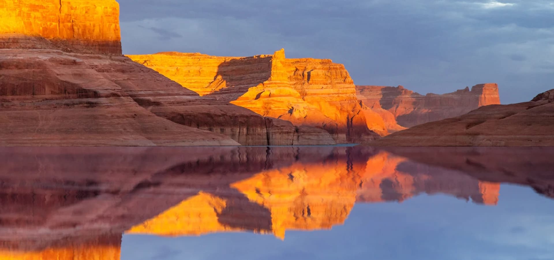 Sunset sandstone cliffs reflected in Lake Powell